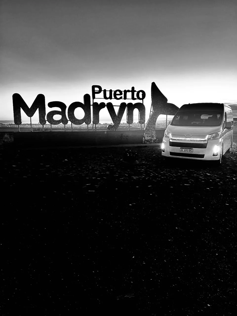 Toyota Hiace de Traslados VIP frente al cartel de Puerto Madryn
